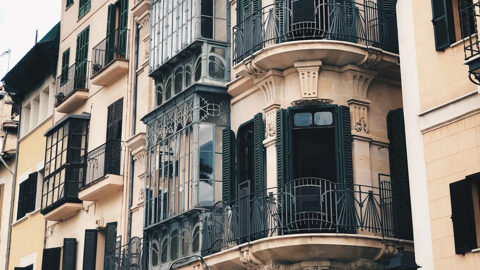 Fachada de un edificio antiguo de Palma con balcones y persianas verdes